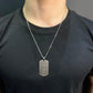 silver dog tag pendant , black shirt , front side